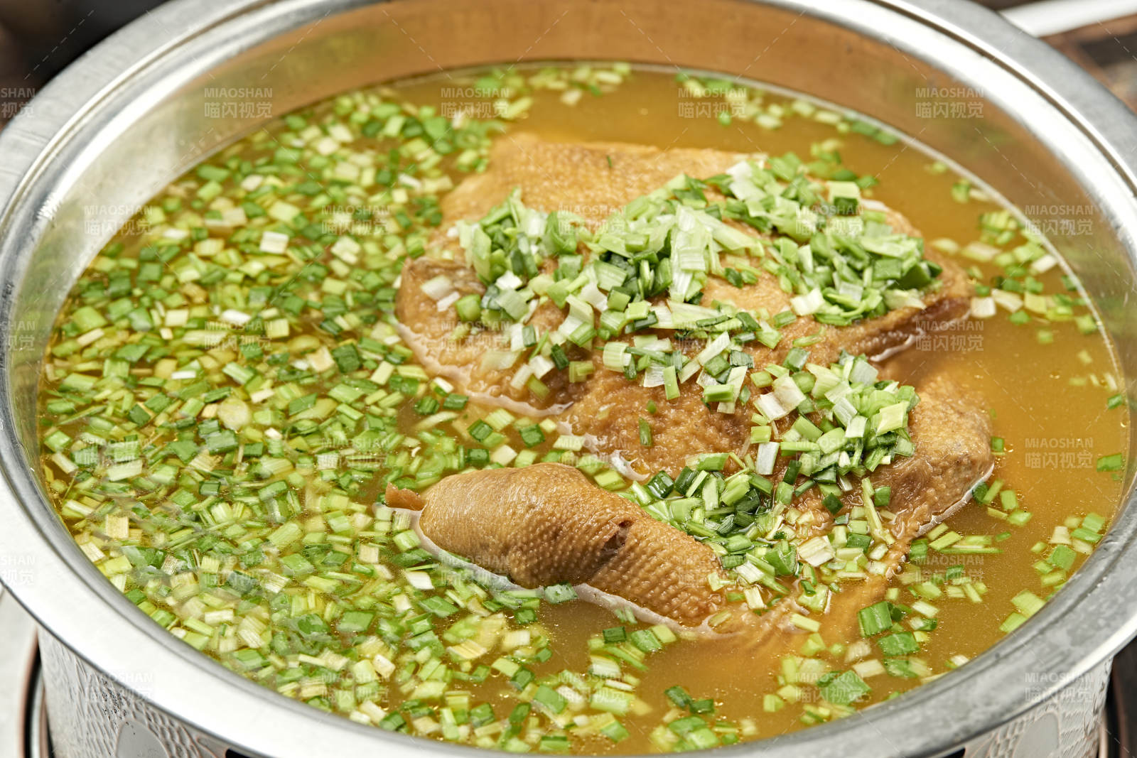 铜锅餐具装的葱香炖煮柴鸡汤