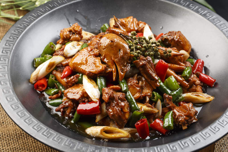 白色瓷盘装的辣炒香芹雪菜猪肚丝