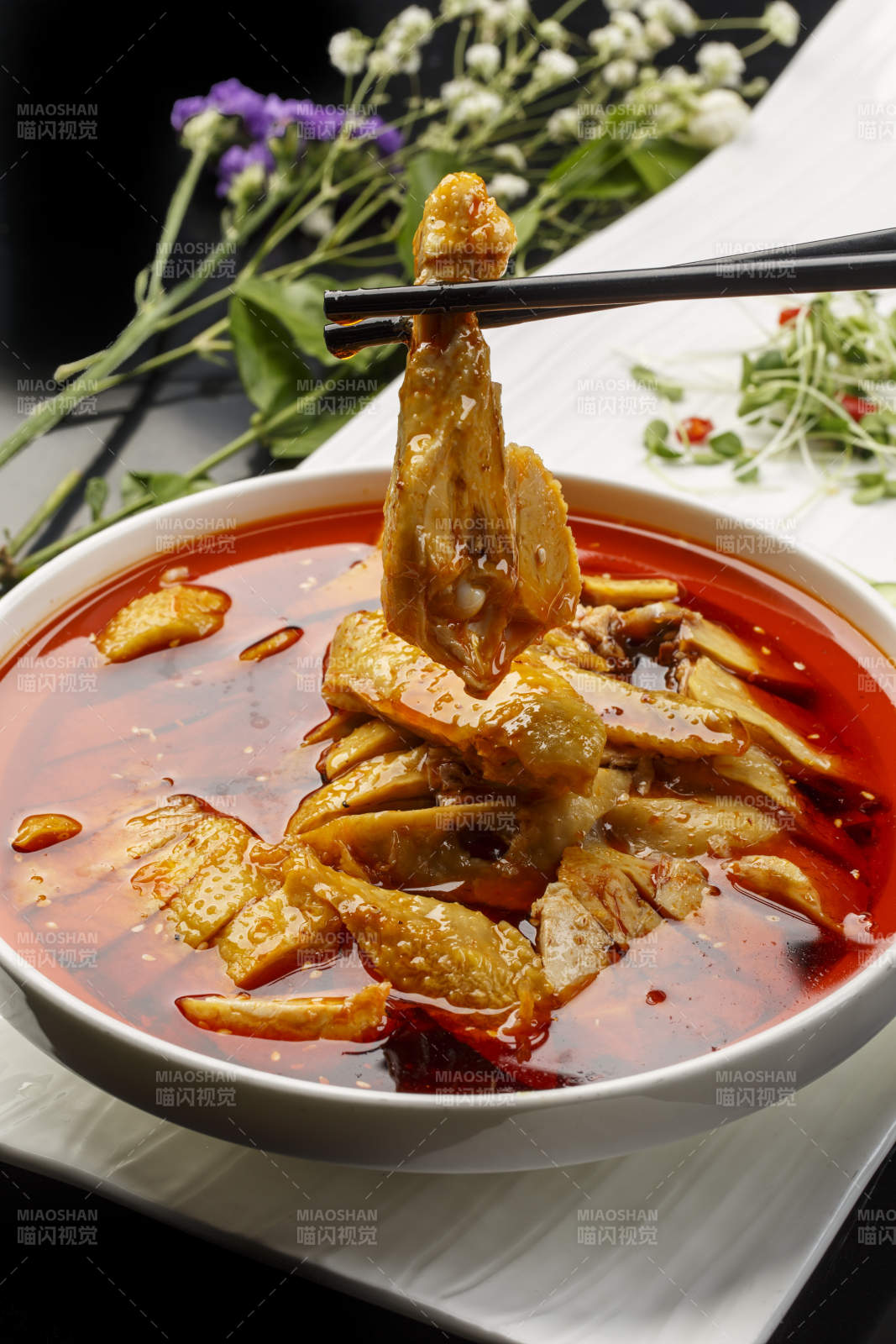 扇形瓷盘摆放的白瓷碗装的麻辣口水鸡