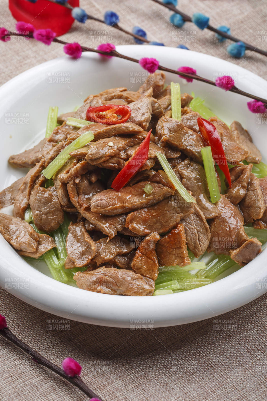 白色圓形瓷盤裝的尖椒炒五花肉