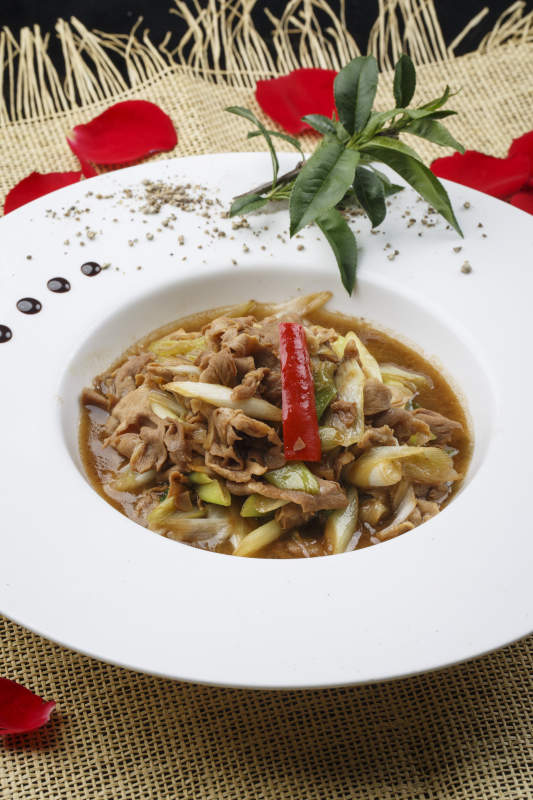 白色圆形瓷盘装的大葱爆羊肉