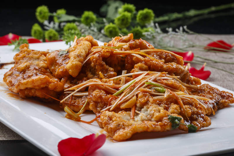 白色圆形瓷盘装的凉拌辣牛舌