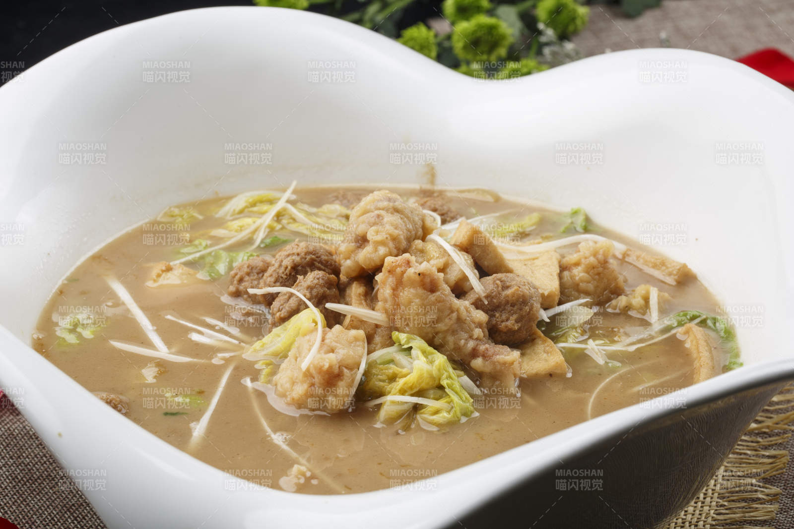 心形白色瓷湯盆裝的酥肉鹵豆泡