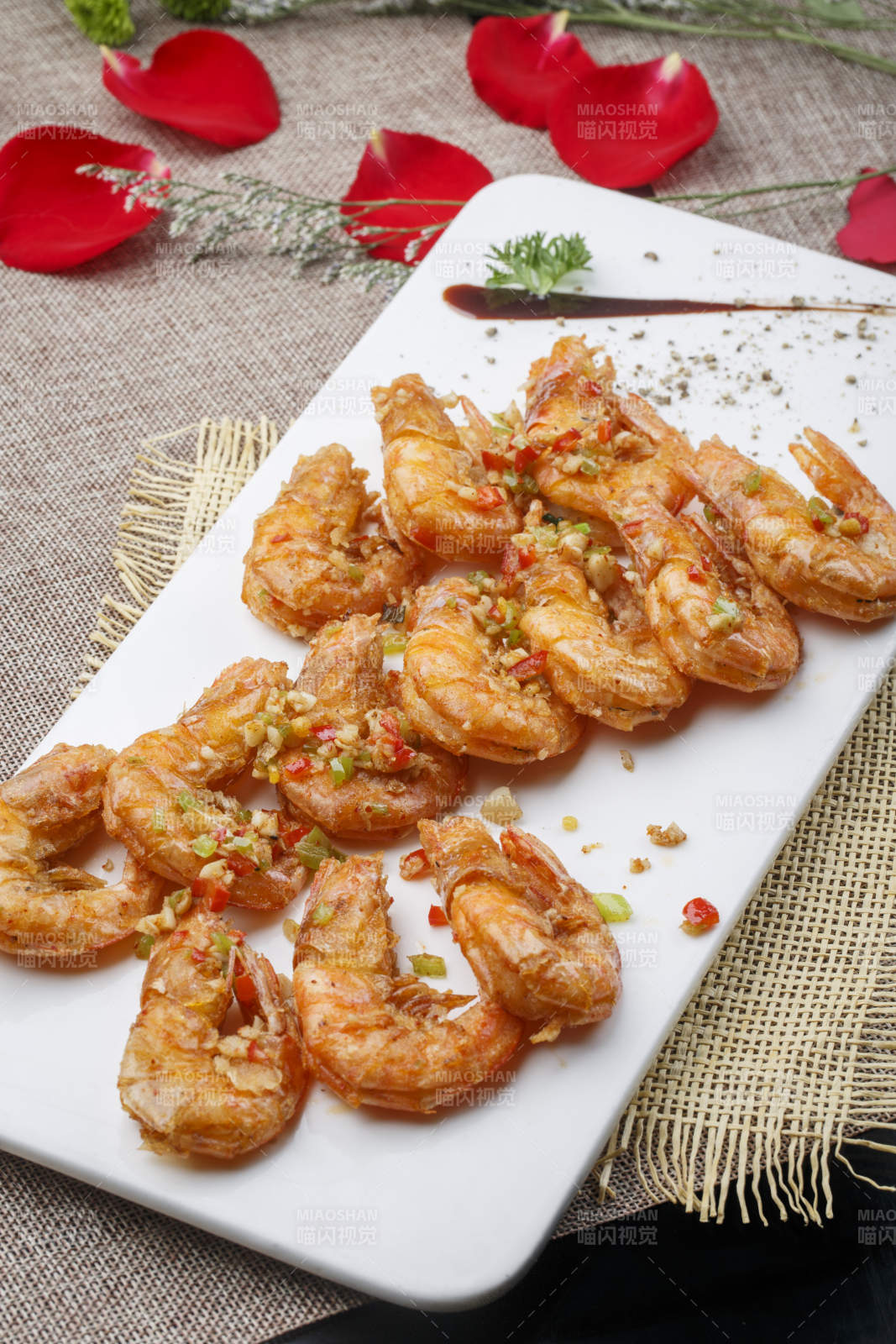 白色椭圆瓷盘装的蒜蓉油炸开背大明虾
