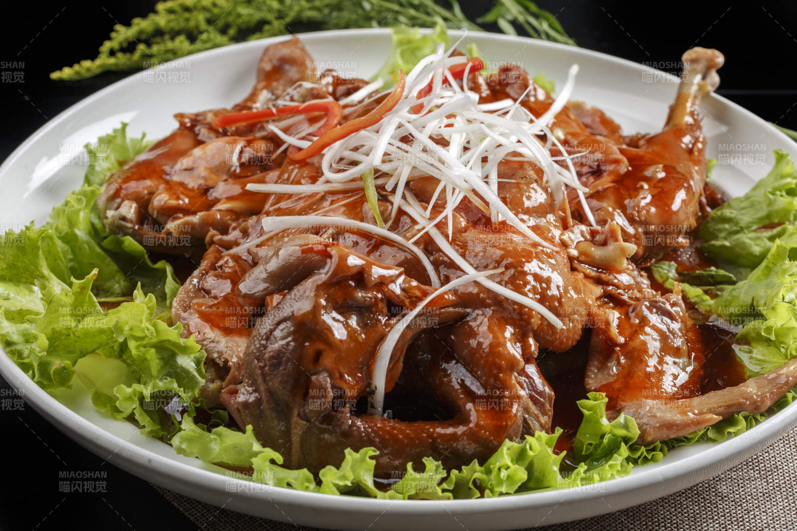 白色瓷盘装的浇汁扒鸡