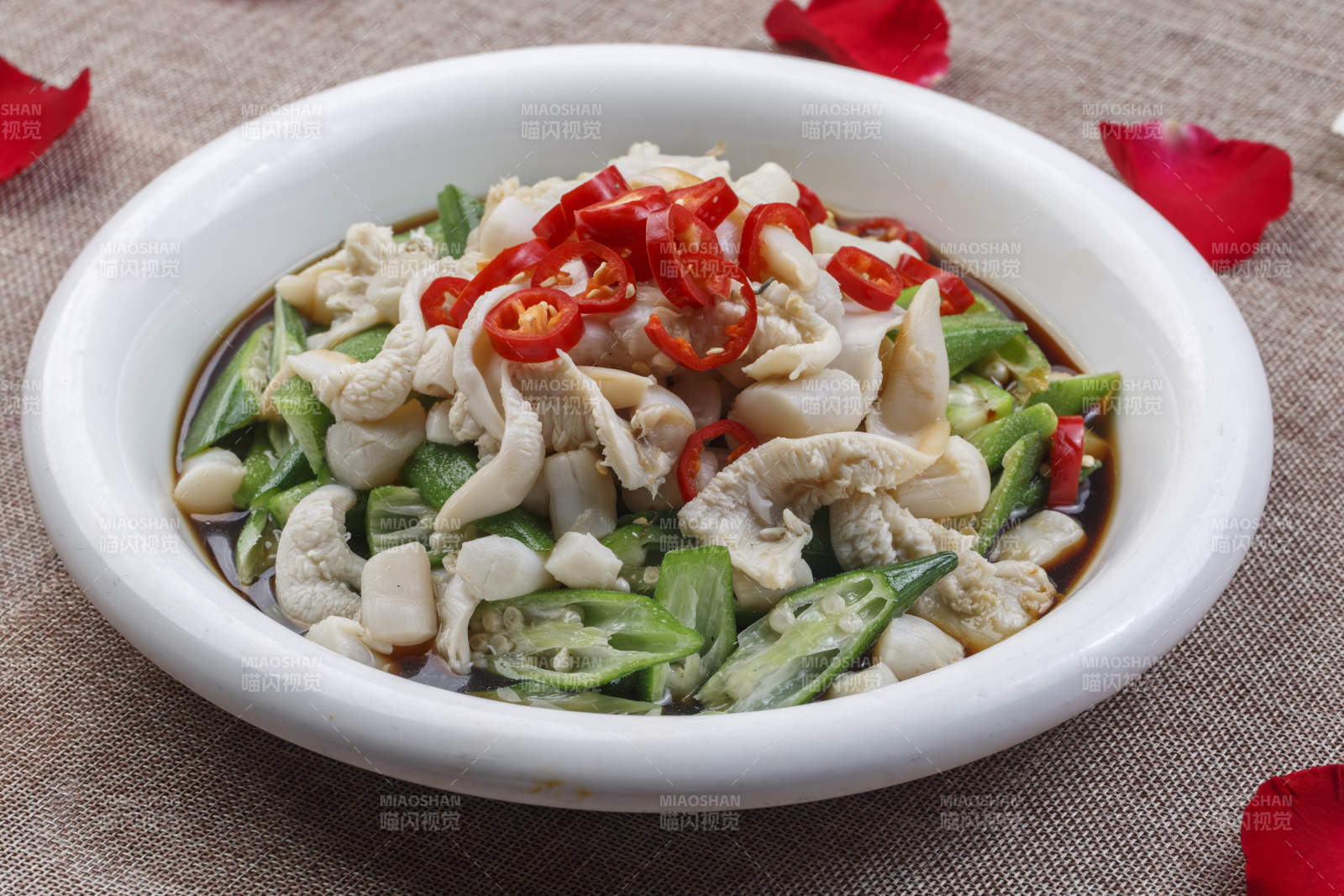 白色圆瓷盘装的秋葵带子肉图片