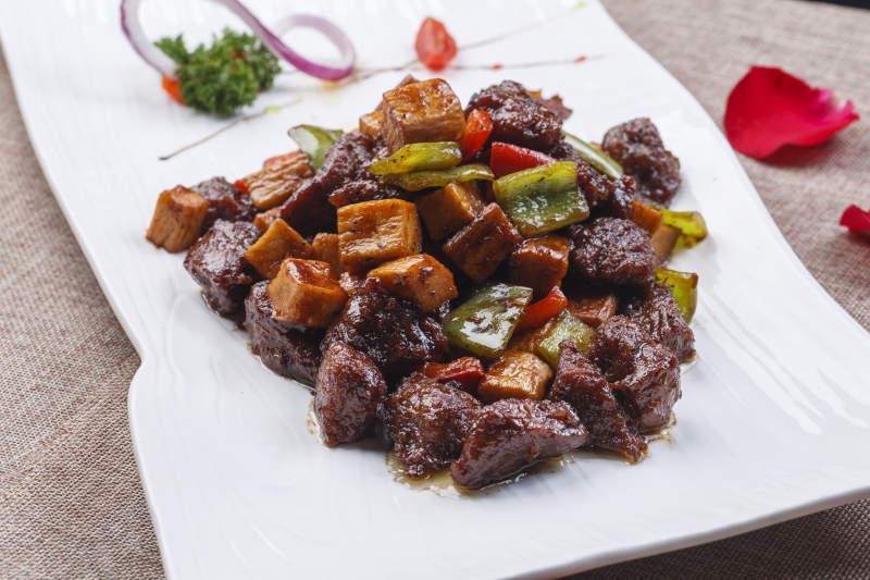 白色长瓷盘装的杏鲍菇牛仔粒