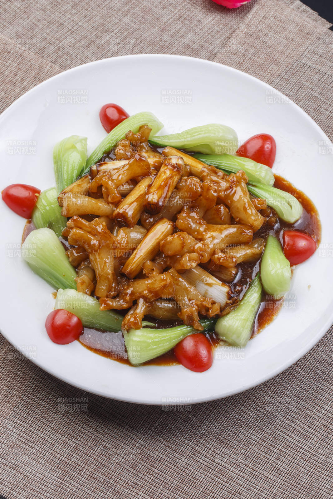 白色圆瓷盘装的葱烧海参蹄筋-摄影图