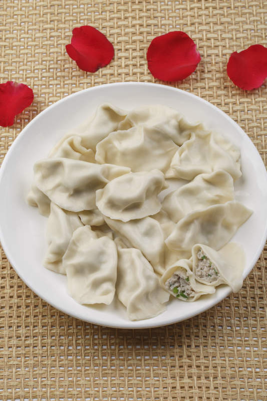 白色瓷盘装的现出锅的海鲜饺子