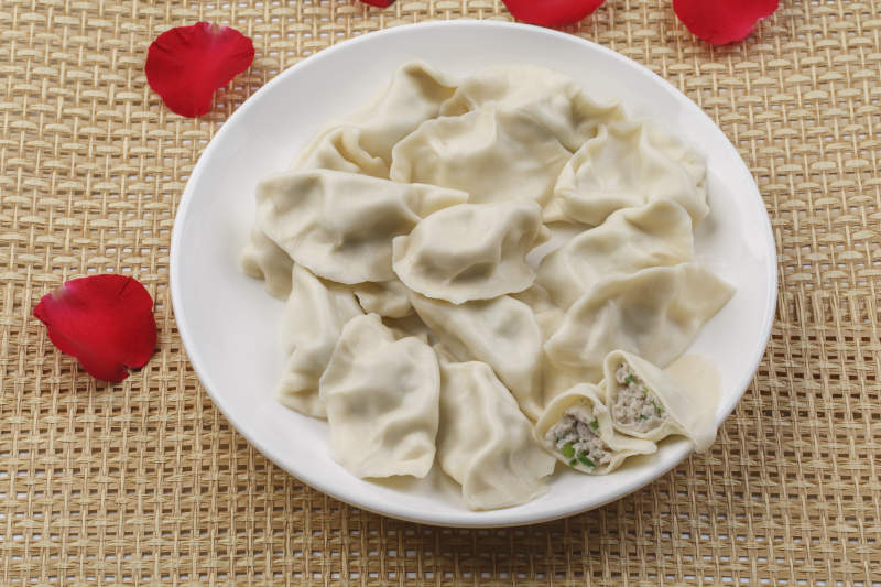 白色瓷盘装的现出锅的海鲜饺子