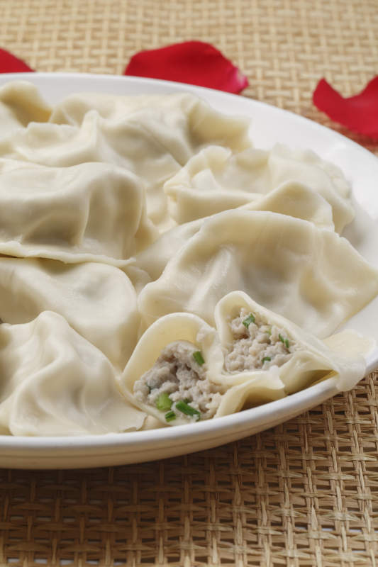 白色瓷盘装的现出锅的海鲜饺子