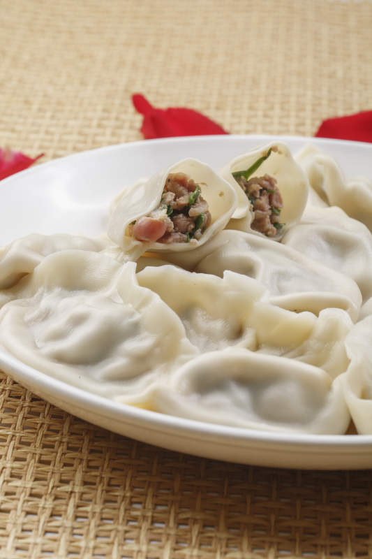 白色瓷盘装的现出锅的海鲜饺子