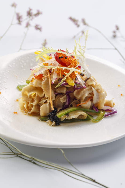 白色瓷盘装的铁板麻辣扇贝裙边