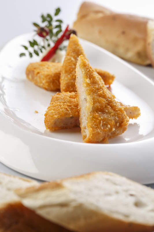 白色瓷盘装的油炸鲜虾饼切块