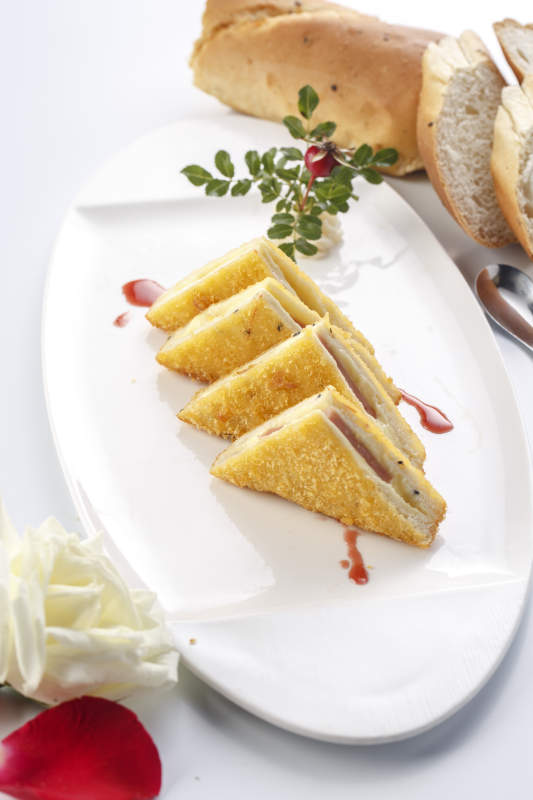 白色瓷盘装的自制早餐三明治