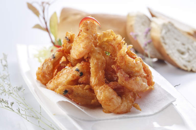 白色瓷盘装的法式铁板椒盐脆皮虾