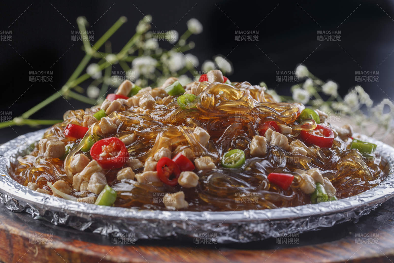 木托板上的锡纸铁板装的香辣鸡丁水晶粉