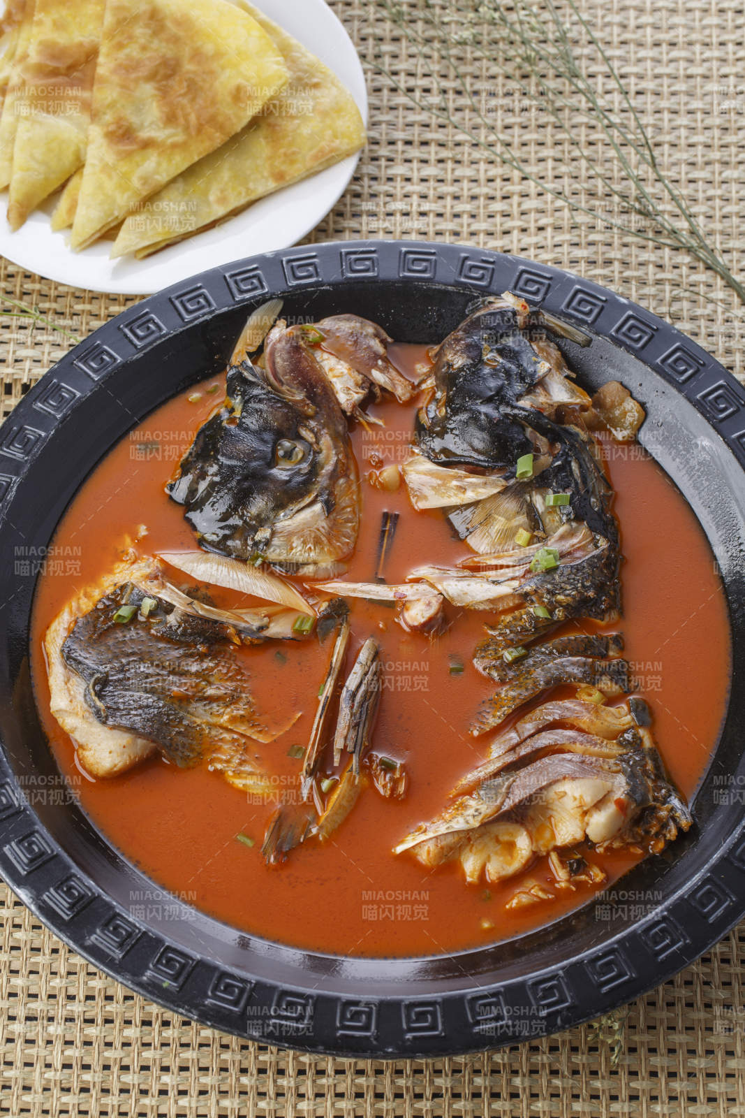 黑色铁盘装的浓汤鱼头泡大饼