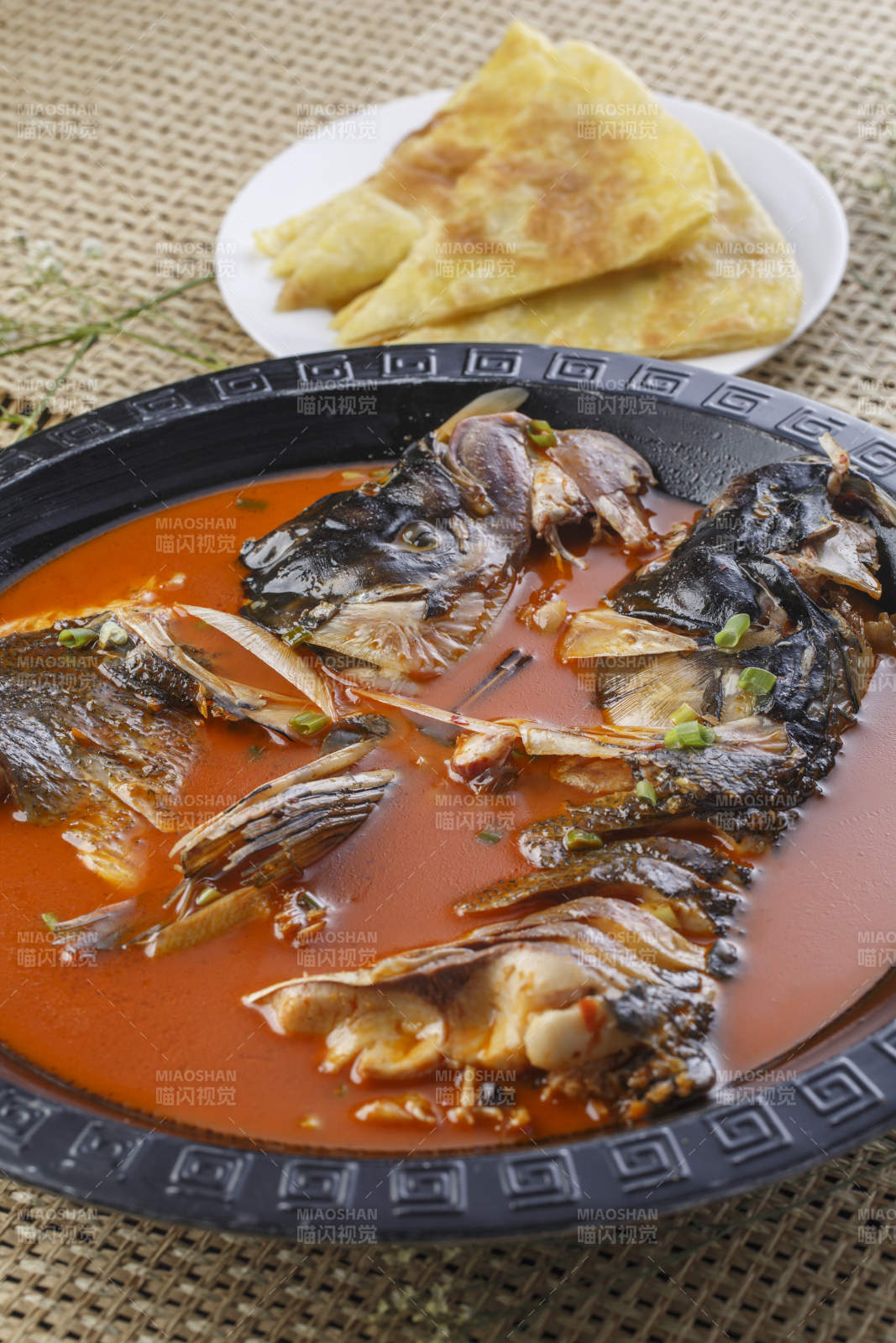 黑色铁盘装的浓汤鱼头泡大饼