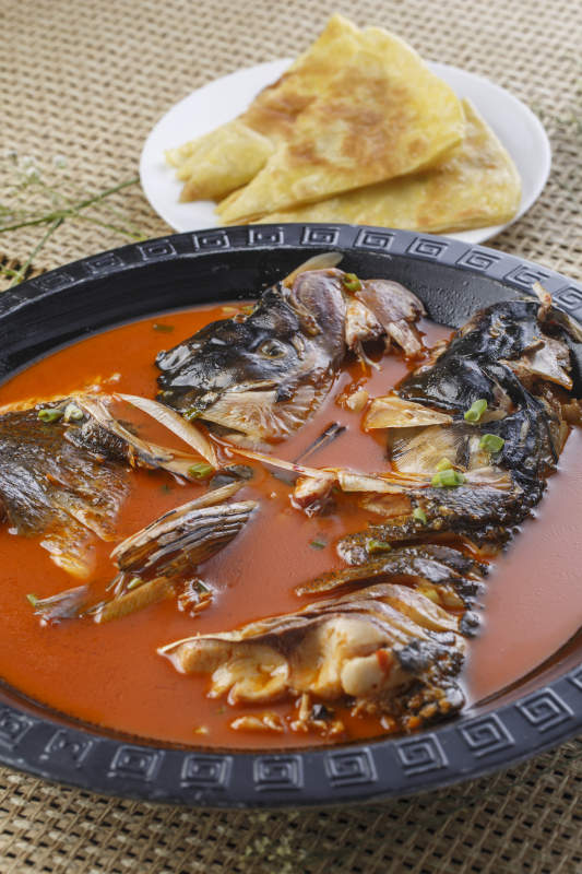 黑色铁盘装的浓汤鱼头泡大饼