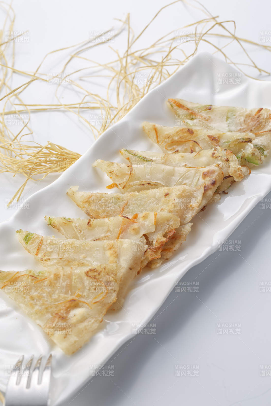 白色瓷盘装的香煎玉米面鸡蛋滩簧饼