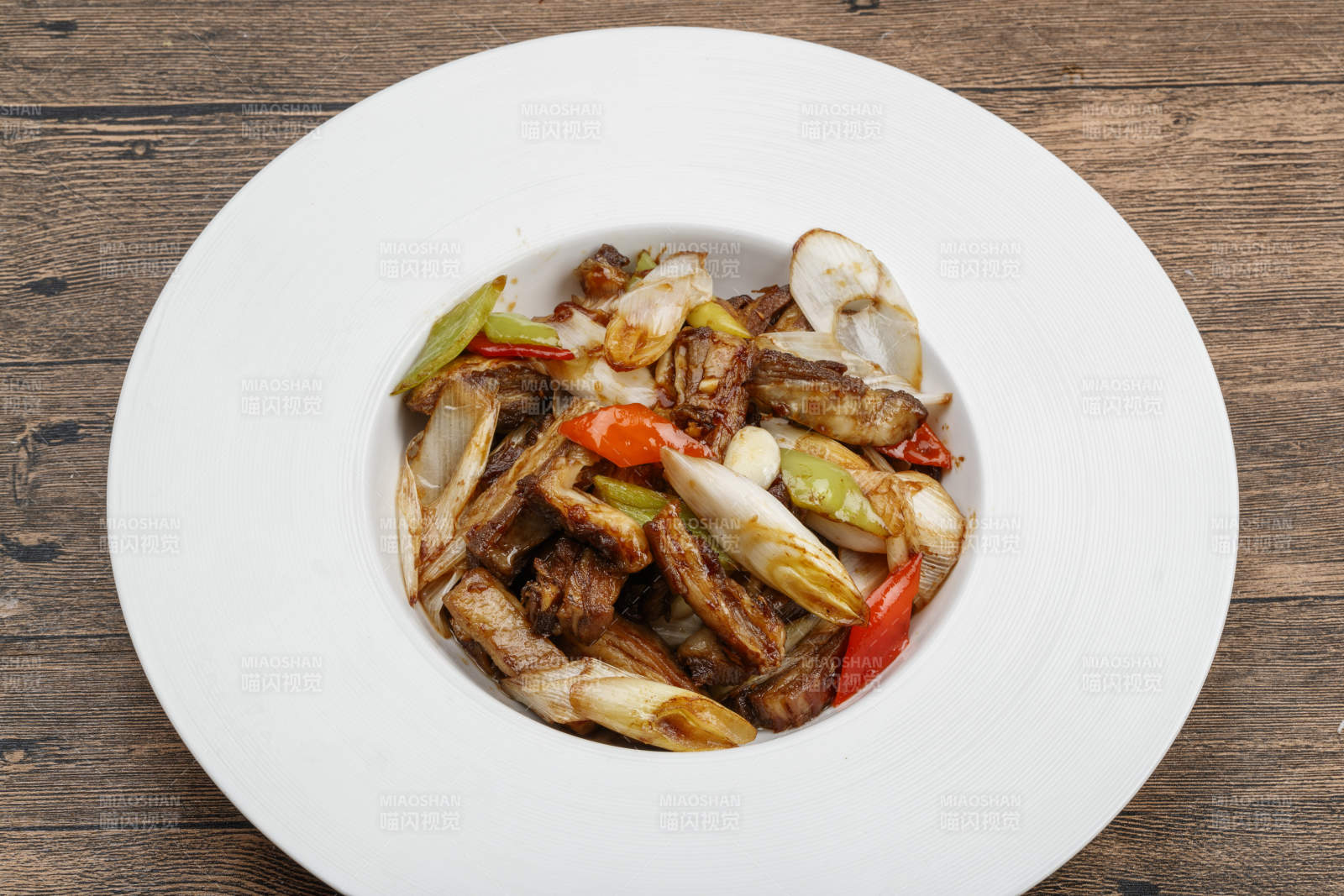 白色瓷盘装的葱爆羊五花肉