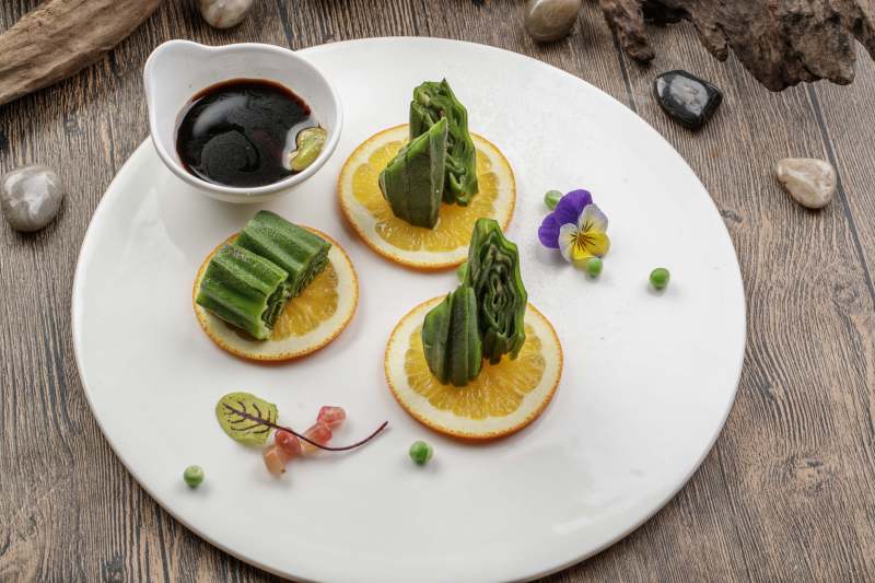 瓷盤裝的甜橙涼拌秋葵