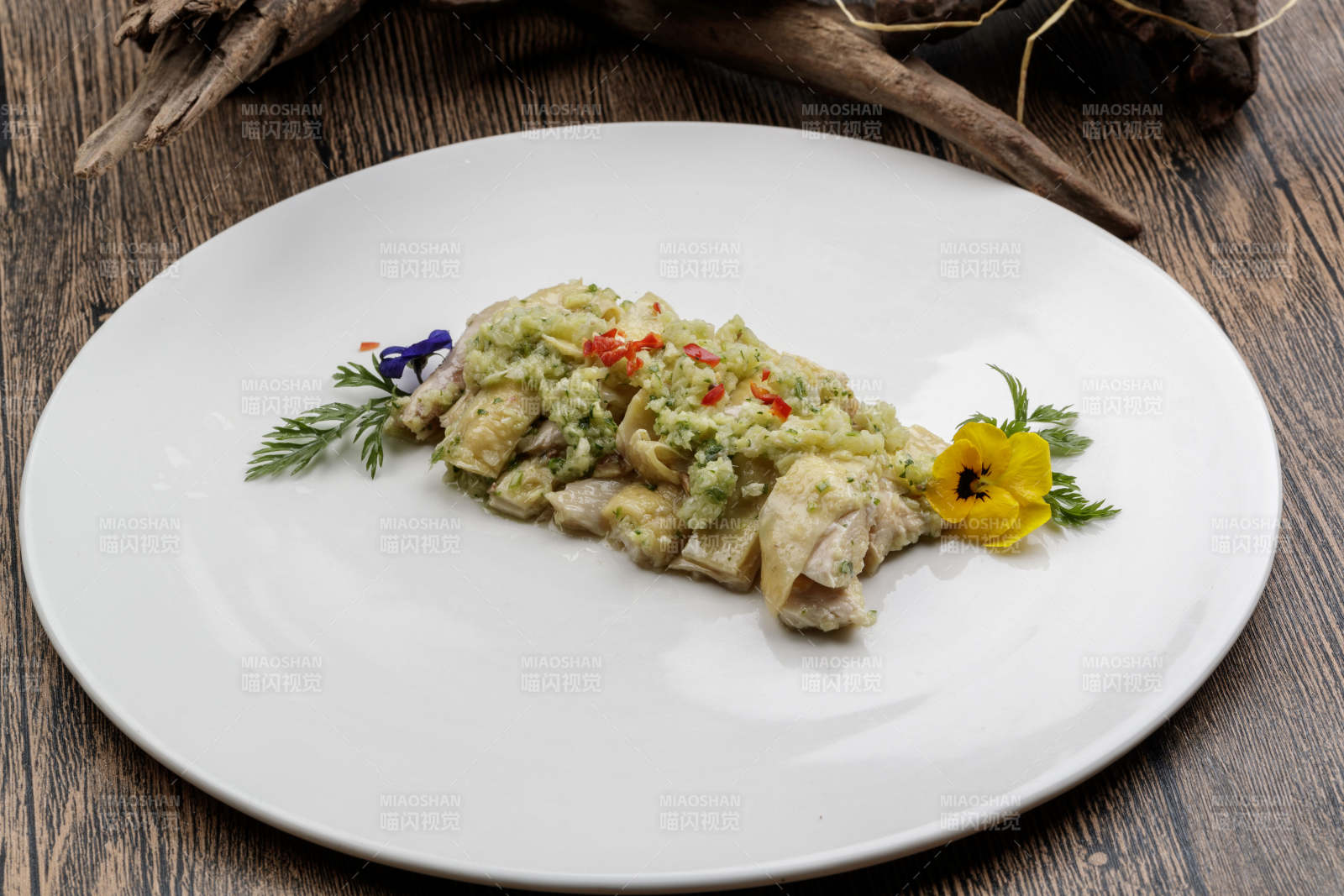 白色瓷盘装的米椒蒜蓉白切鸡