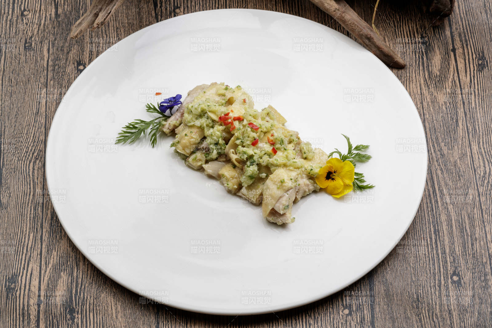 白色瓷盘装的米椒蒜蓉白切鸡