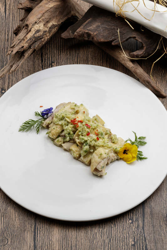 白色瓷盘装的米椒蒜蓉白切鸡