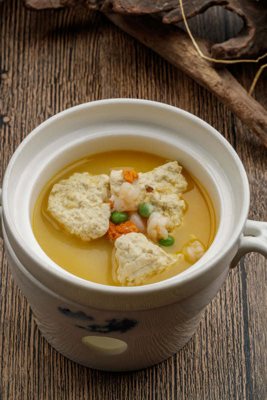 白色瓷汤中装的浓汤虾仁炖鱼子