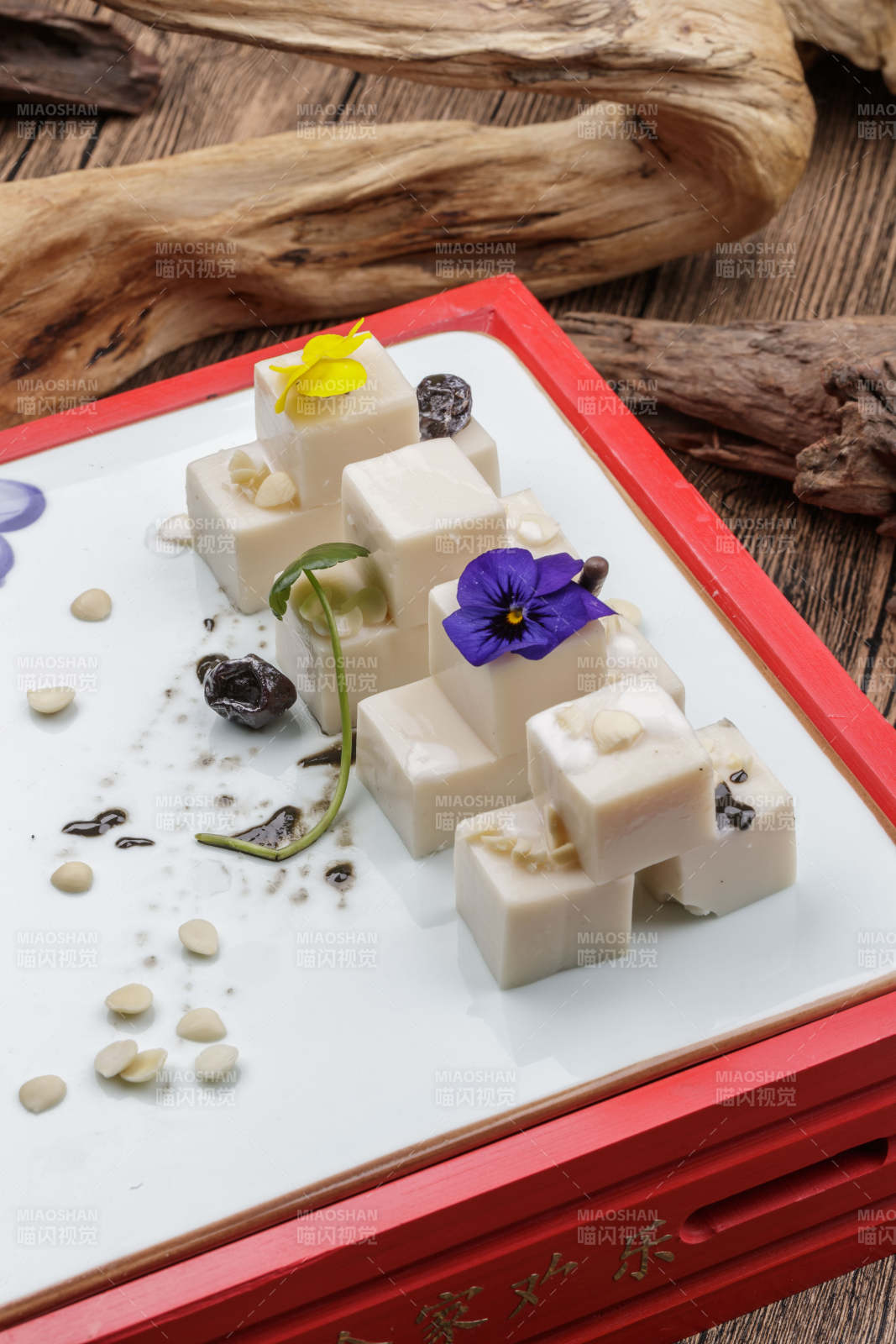 圆形黑色石盘装的奶香杏仁糕摆放在寿司帘上