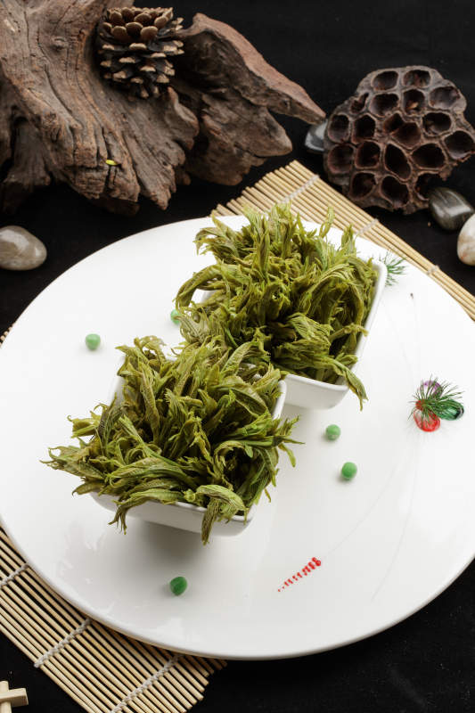 白色瓷盤裝的鹽水涼拌香椿苗