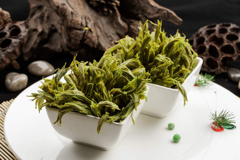 白色瓷盤裝的鹽水涼拌香椿苗