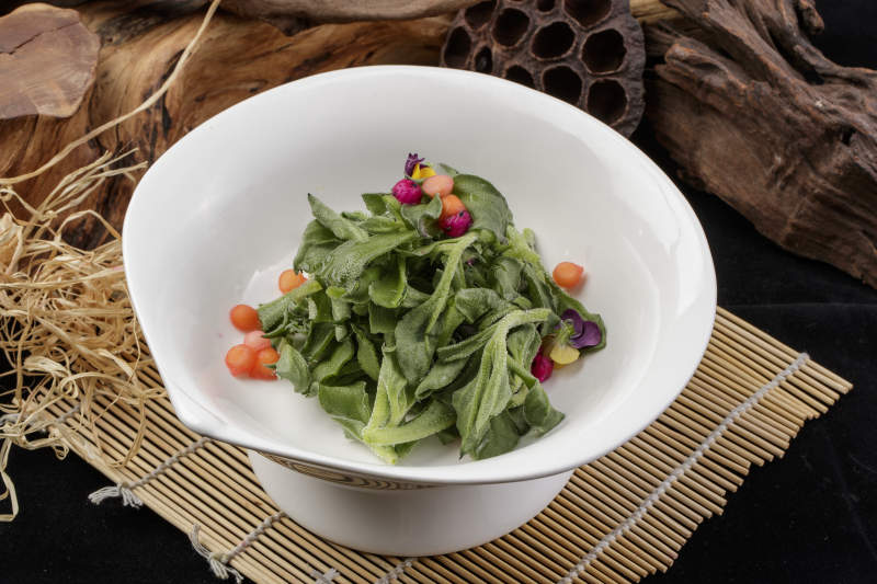 新鲜脆嫩的凉拌穿心莲摆放在黑色背景上