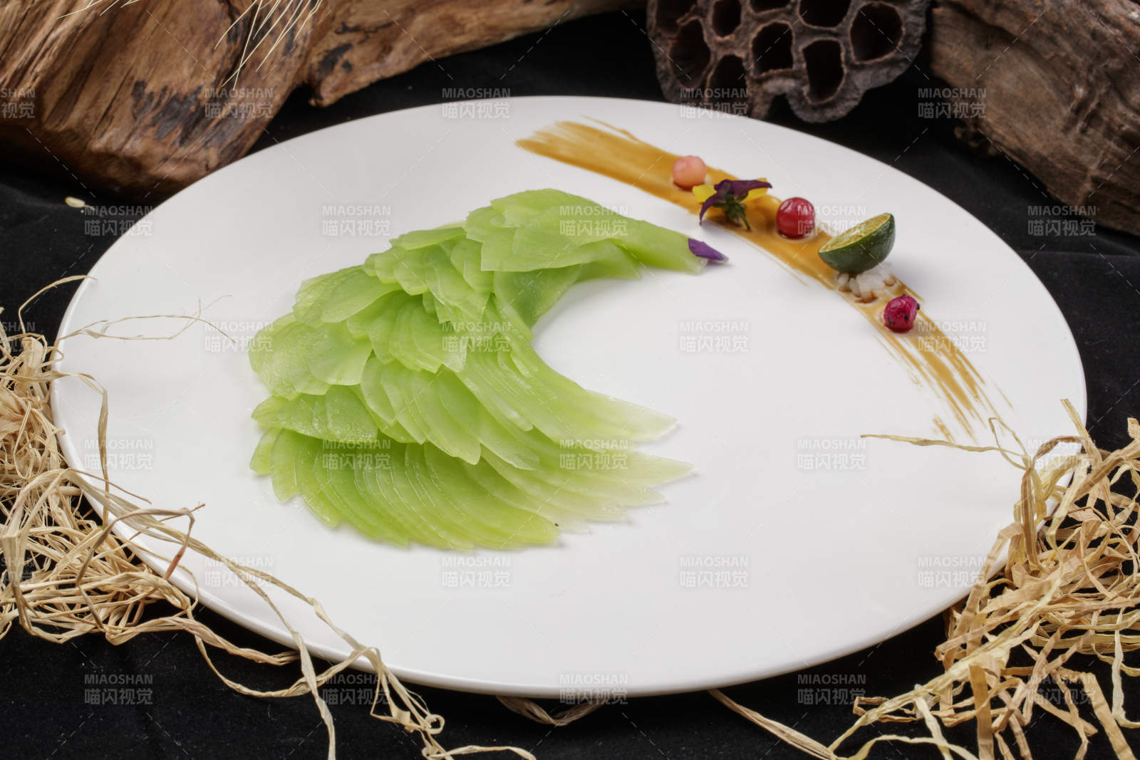 白色圆瓷盘装的凤尾青笋摆放在黑色背景上-摄影图