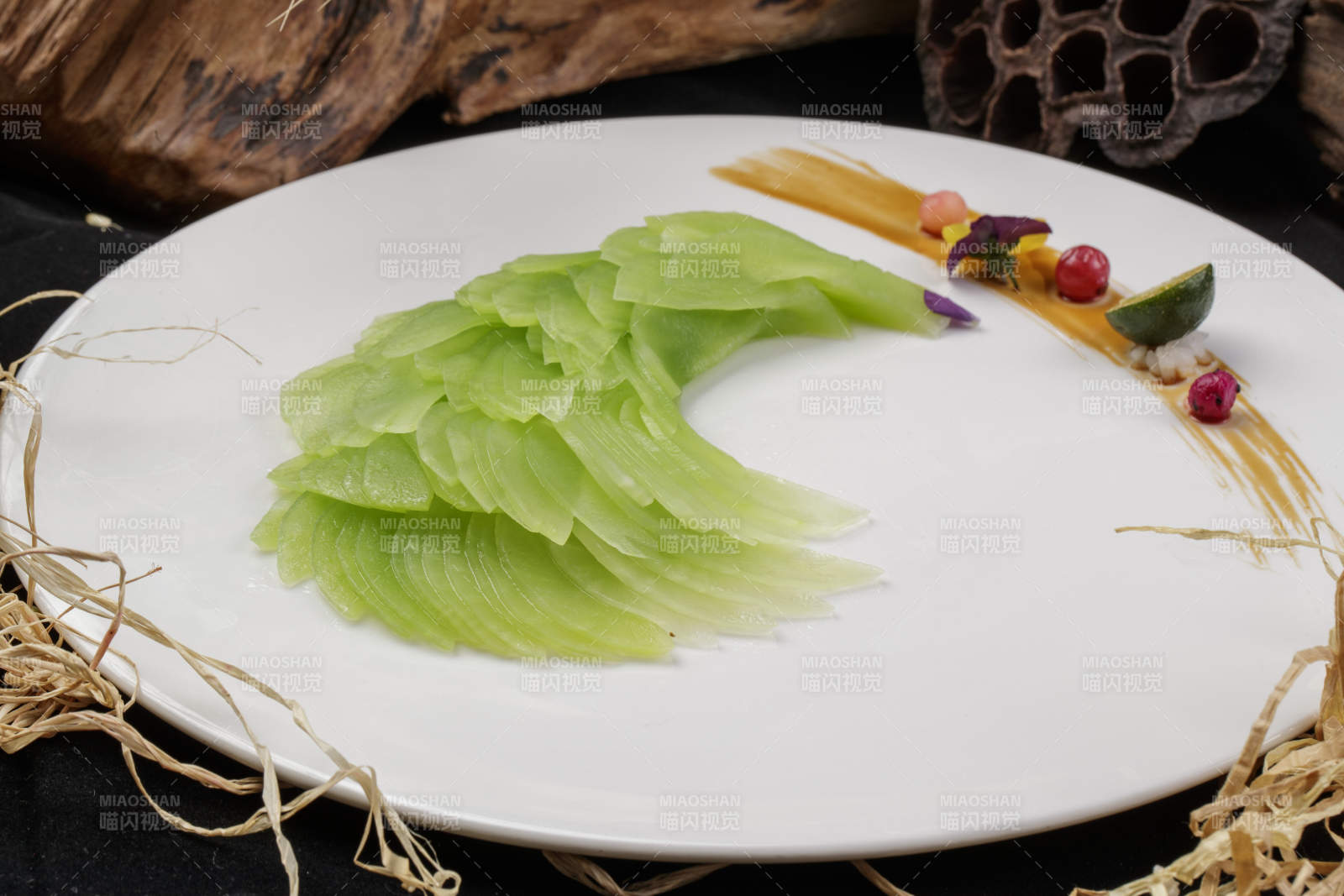 白色圆瓷盘装的凤尾青笋摆放在黑色背景上-摄影图