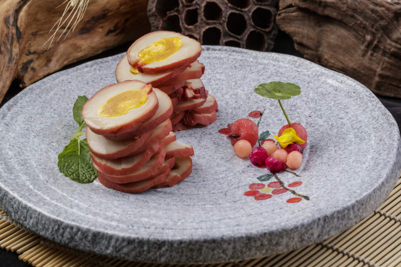 鱿鱼卷海鸭蛋摆放在寿司帘上