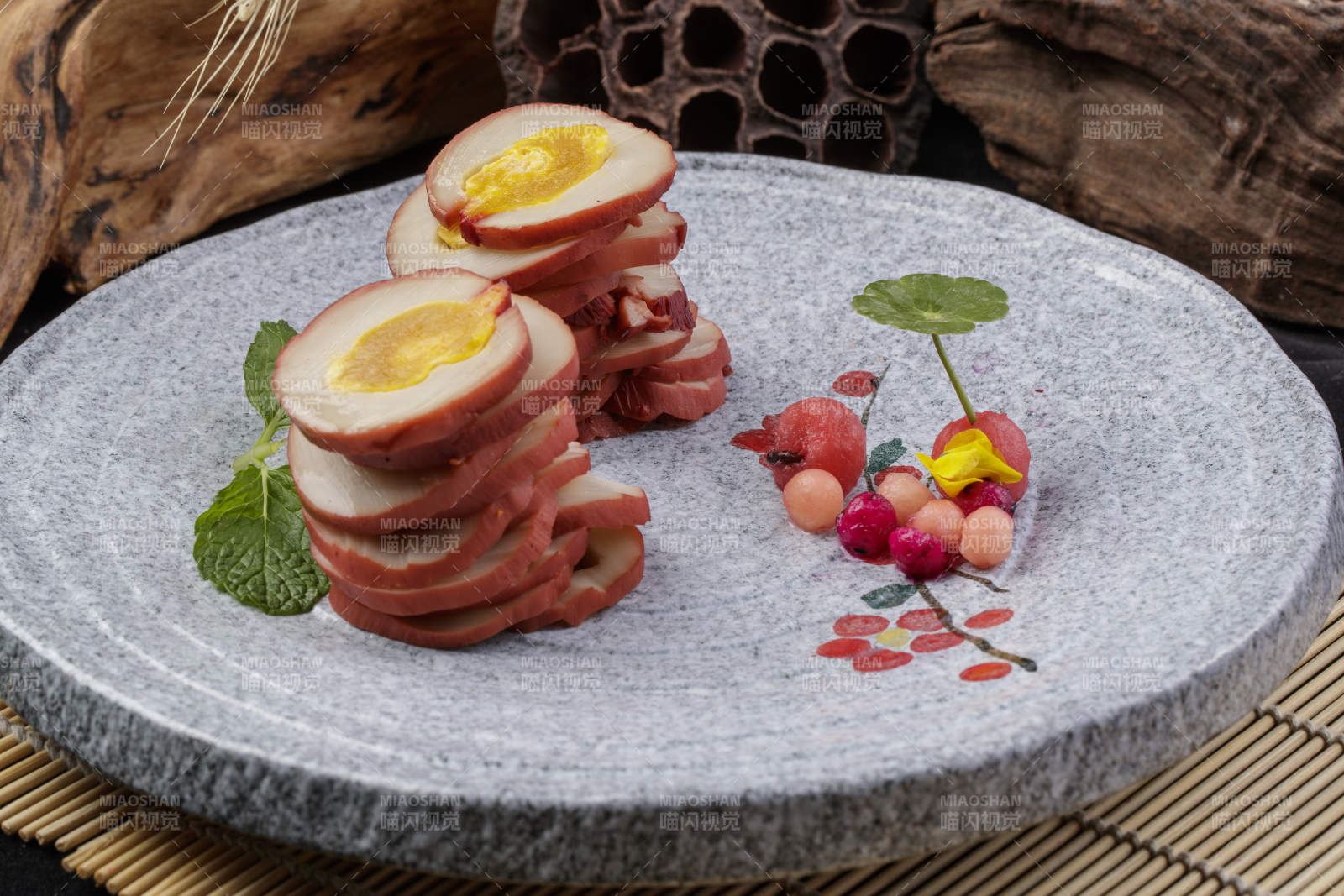 鱿鱼卷海鸭蛋摆放在寿司帘上图片