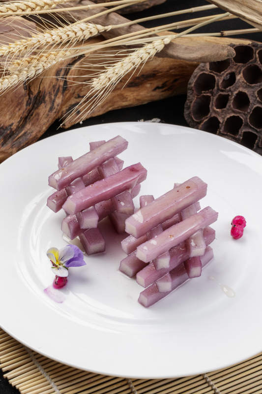 圆形瓷盘装的蓝莓长山药摆放在寿司帘上