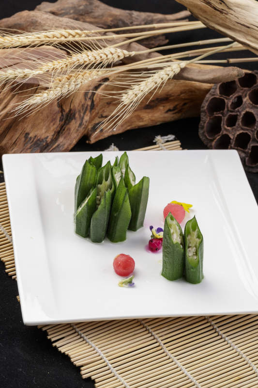 長方形瓷盤裝的鮮秋葵擺放在壽司簾上