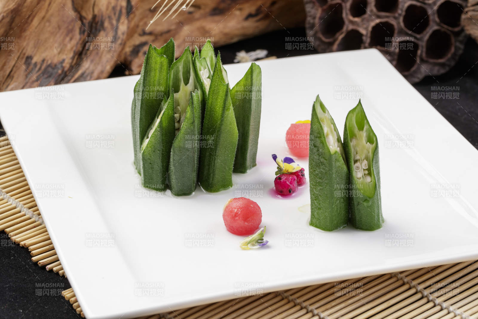 長(zhǎng)方形瓷盤裝的鮮秋葵擺放在壽司簾上