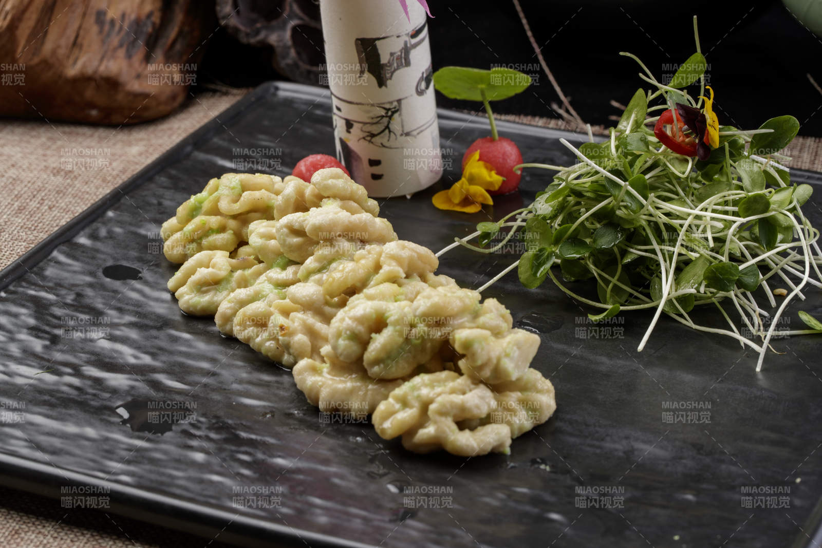 黑色瓷盤裝的飄香桃仁黑豆苗