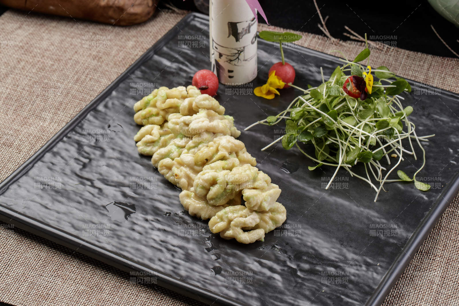 黑色瓷盤裝的飄香桃仁黑豆苗