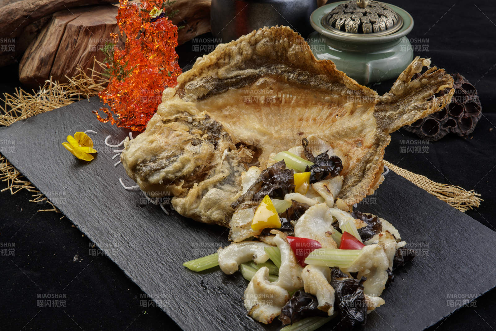 黑色石板裝的兩吃香酥多寶魚擺放在黑色背景上