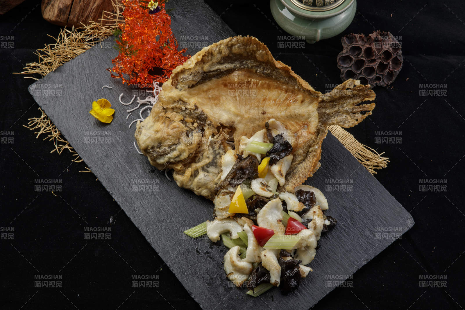 黑色石板裝的兩吃香酥多寶魚擺放在黑色背景上