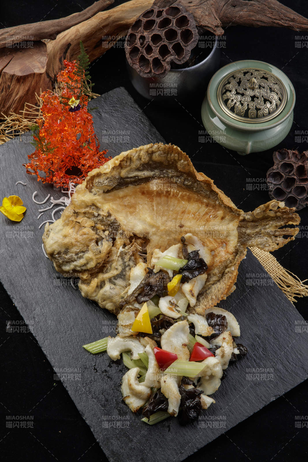 黑色石板裝的兩吃香酥多寶魚擺放在黑色背景上