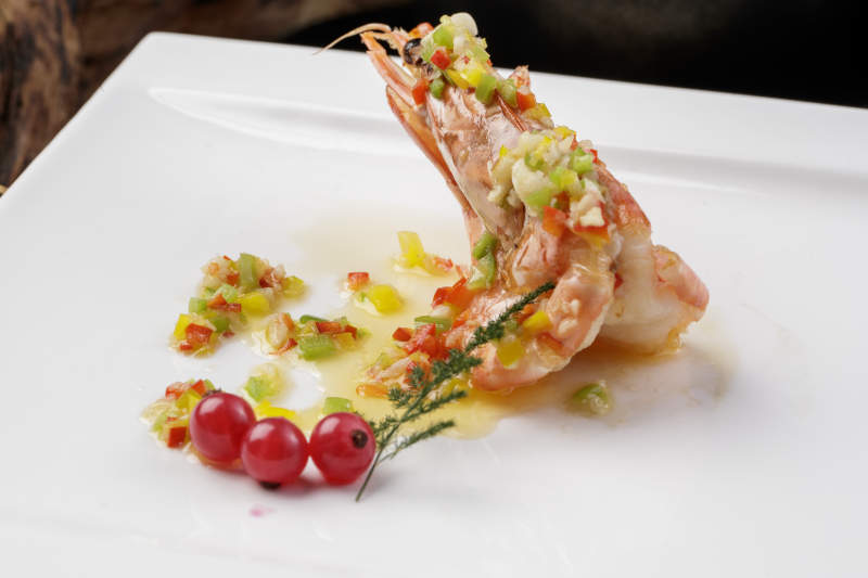 方形瓷盘装的开背大虾摆放在樟木砧板上