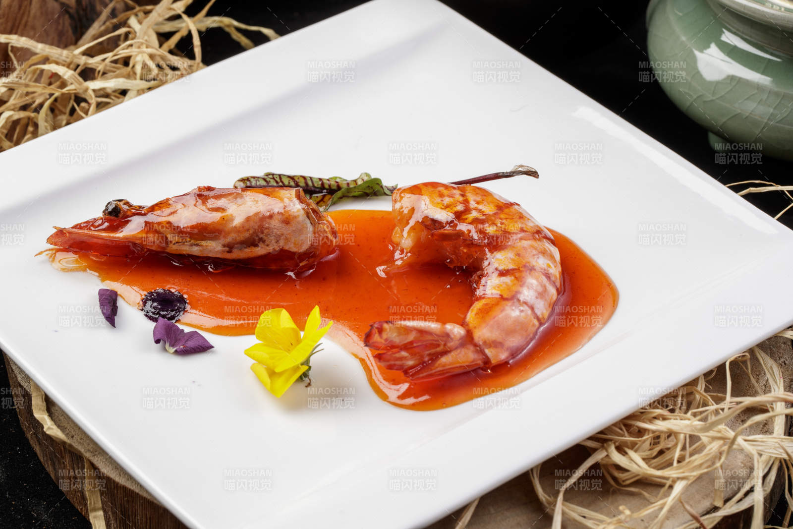 方形瓷盤裝的澆汁大明蝦擺放在樟木砧板上