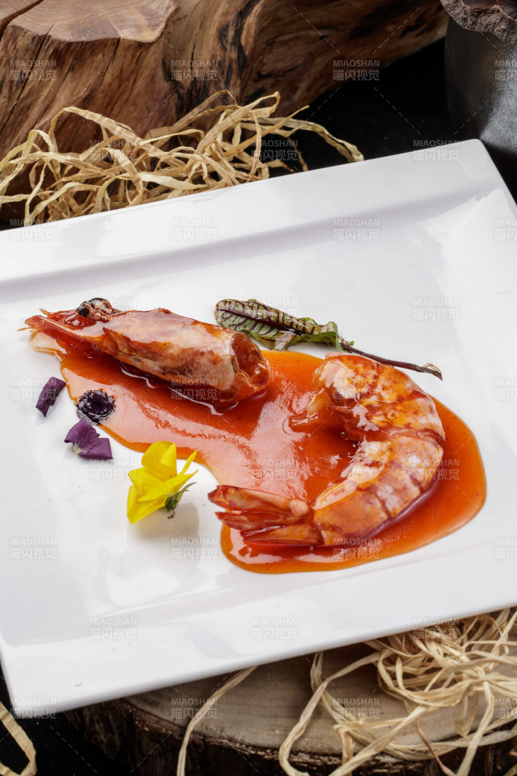 方形瓷盤裝的澆汁大明蝦擺放在樟木砧板上